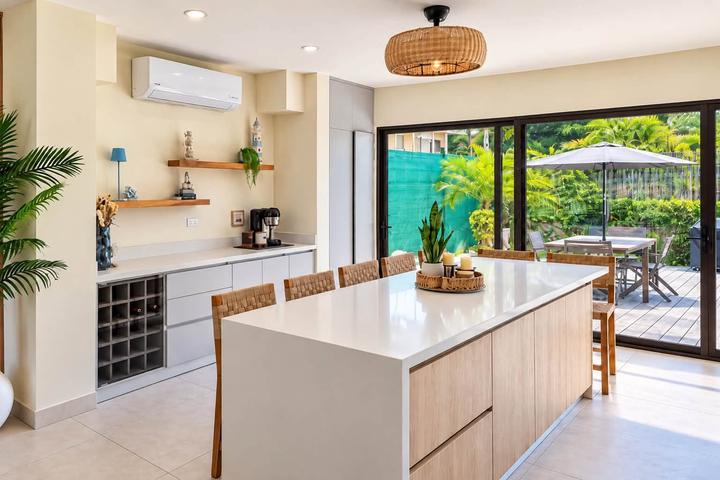 Cocina abierta con isla y banquetas de madera tejida