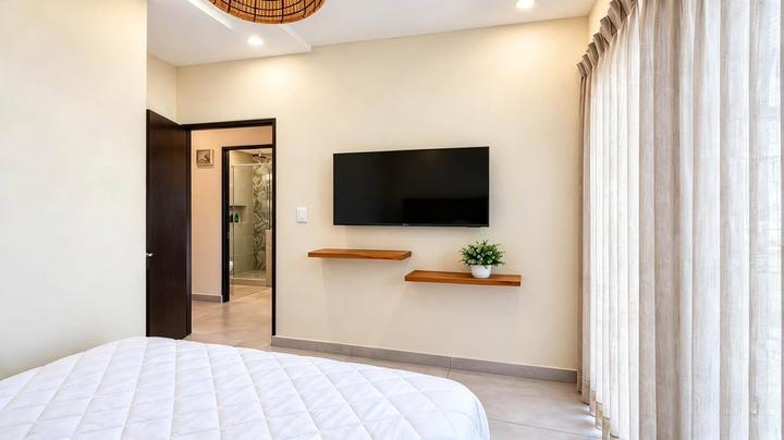 Segundo dormitorio con televisor y baño