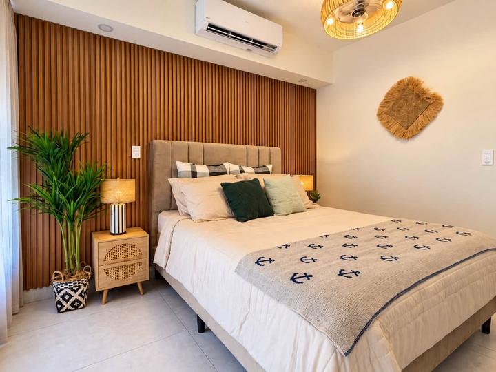 Dormitorio principal con pared de madera y manta con anclas